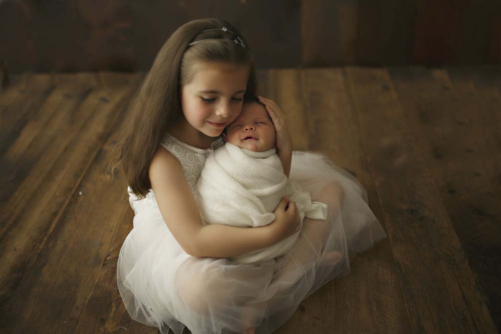 newborn with girl in dress